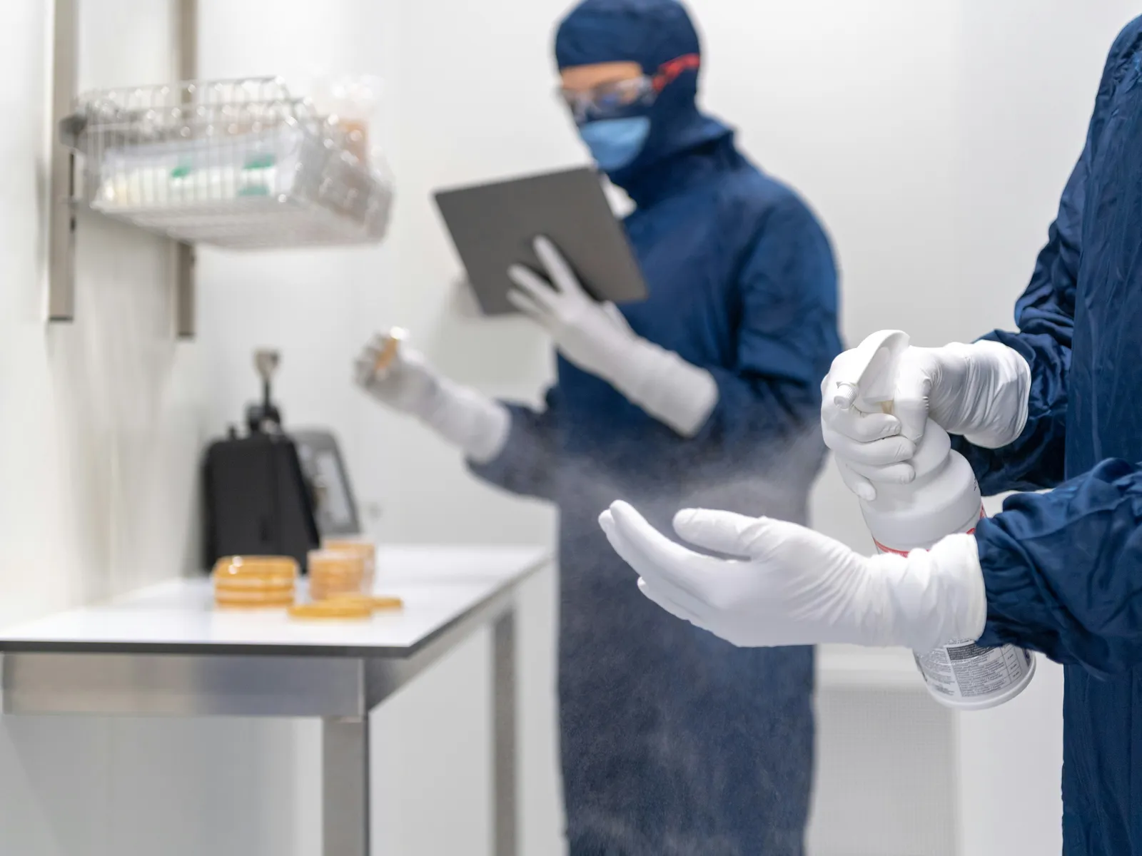 Pharmaceutical cleanroom technicians in PPE and prescription safety eyewear
