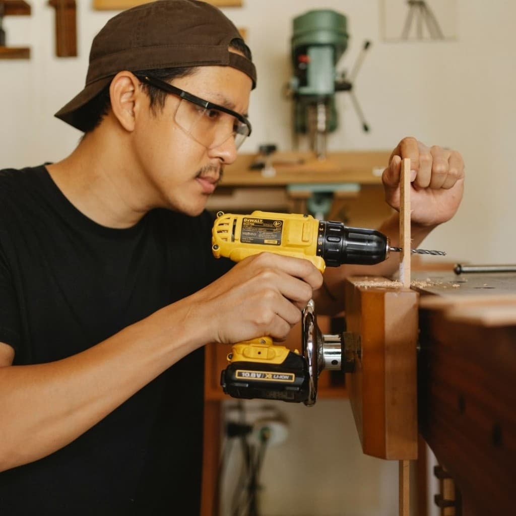 Worker wearing On-Sight prescription safety glasses while using a power drill