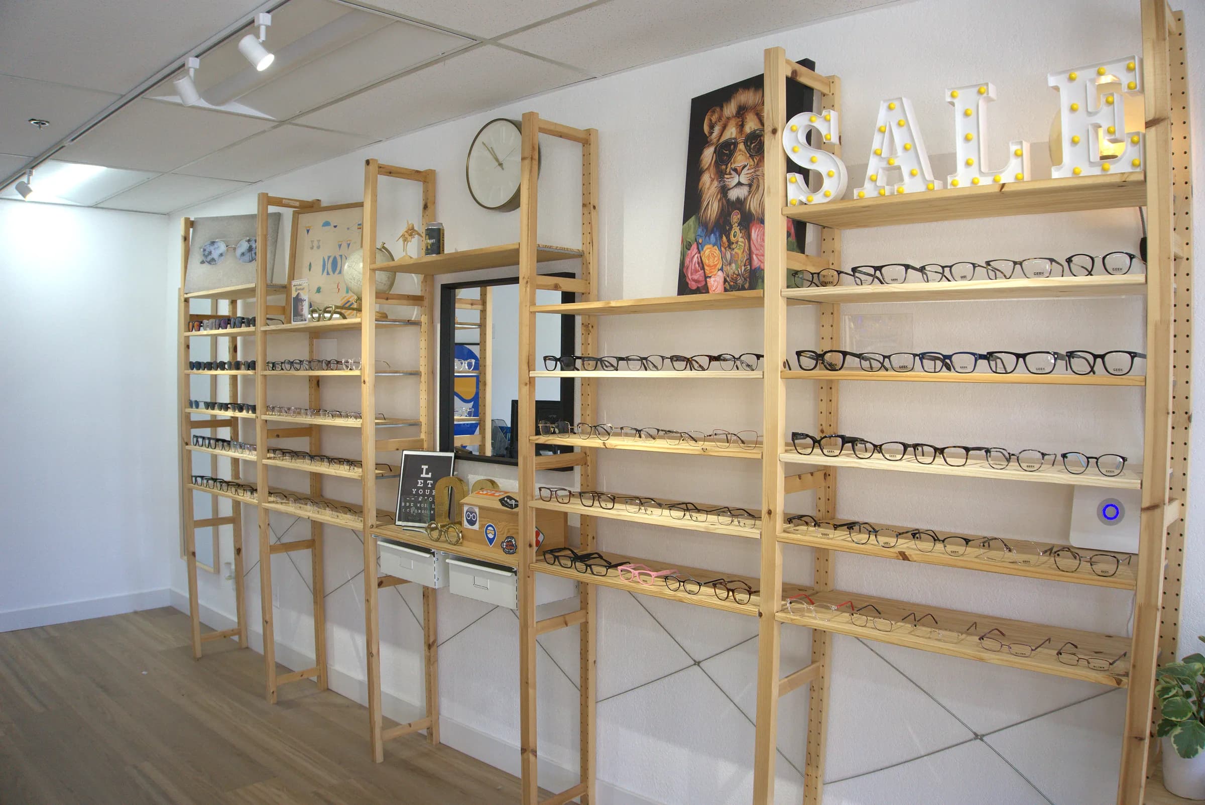 Eyeglass frames arranged across the showroom's wooden display wall